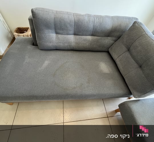 ספה אפורה עם כתם על הריפוד